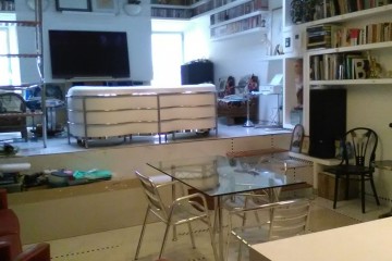 Ristrutturazione, arredo e allestimento abitazione open space in Trastevere, Roma. Ambiente soggiorno-pranzo su più livelli, veduta lato destro